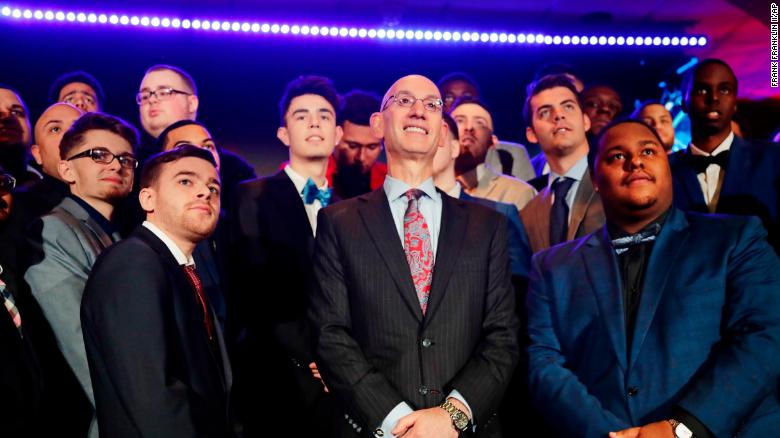 NBA Commissioner Adam Silver, center, poses for photographs with gamers at the NBA 2K League draft in April, 2018. 