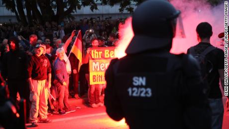 Riot police watch right-wing supporters the day after a man was stabbed to death in Chemnitz.