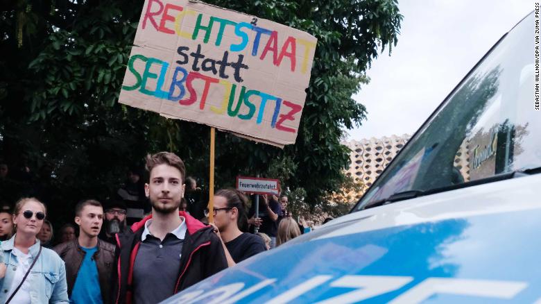 An anti-Nazi protester holds a sign reading, &quot;Rule of law instead of vigilante justice,&quot; on Monday in Chemnitz.