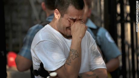 Jessie Cobos weeps as he views a memorial outside the home in Little Village.