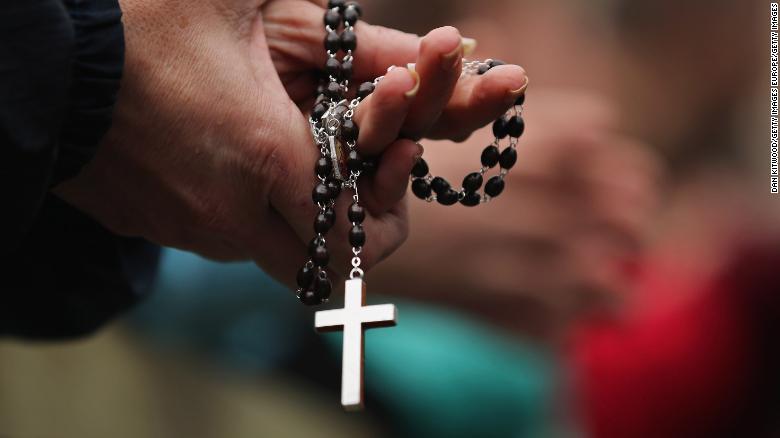 VATICAN CITY, VATICAN - MARCH 13:  A woman holds rosary beads while she prays and waits for smoke to emanate from the chimney on the roof of the Sistine Chapel which will indicate whether or not the College of Cardinals have elected a new Pope on March 13, 2013 in Vatican City, Vatican. Pope Benedict XVI's successor is being chosen by the College of Cardinals in Conclave in the Sistine Chapel. The 115 cardinal-electors, meeting in strict secrecy, will need to reach a two-thirds-plus-one vote majority to elect the 266th Pontiff.  (Photo by Dan Kitwood/Getty Images)