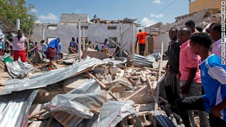 Somalis search wreckage at the scene of a blast outside the compound of a district headquarters in Mogadishu, Somalia, on Sunday, September 2. 