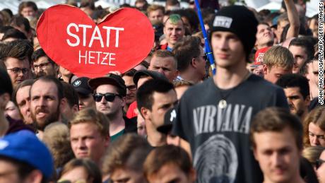 A crowd member holds a sign reading "Instead of hate" at the concert in Chemnitz.