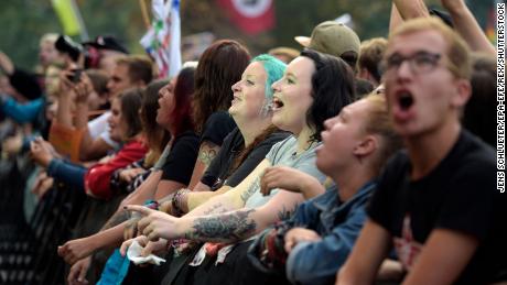 Concert-goers in the front row cheer on performers.