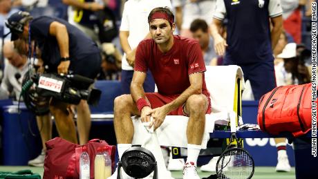 Federer sits on the baseline following defeat.