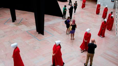 Women dressed as characters from the novel-turned-TV series "The Handmaid's Tale" walk through the Hart Senate Office Building as Supreme Court nominee Brett Kavanaugh starts the first day of his confirmation hearing.