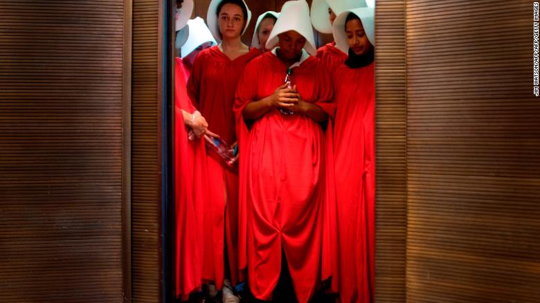 Women dressed as characters from "The Handmaid's Tale" stand in an elevator at the Hart Senate Office Building as Supreme Court nominee Brett Kavanaugh starts the first day of his confirmation hearing.