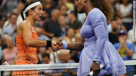 Williams and Sevastova shake hands at the net after their match.