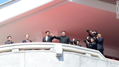 North Korean leader Kim Jong Un and Chinese envoy Li Zhanshu clasp hands.