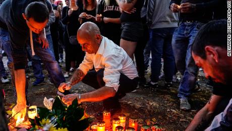 People light candles at the crime scene in Koethen where a 22-year-old man was found severely injured late Saturday.