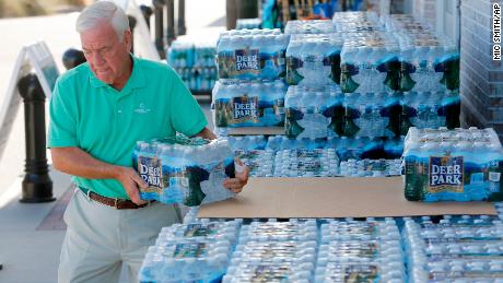 Larry Pierson, from the Isle of Palms, S.C., purchases bottled water from the Harris Teeter grocery store on the Isle of Palms in preparation for Hurricane Florence at the Isle of Palms S.C., Monday, Sept. 10, 2018. (AP Photo/Mic Smith)