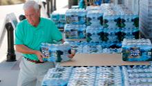 Larry Pierson, from the Isle of Palms, S.C., purchases bottled water from the Harris Teeter grocery store on the Isle of Palms in preparation for Hurricane Florence at the Isle of Palms S.C., Monday, Sept. 10, 2018. (AP Photo/Mic Smith)