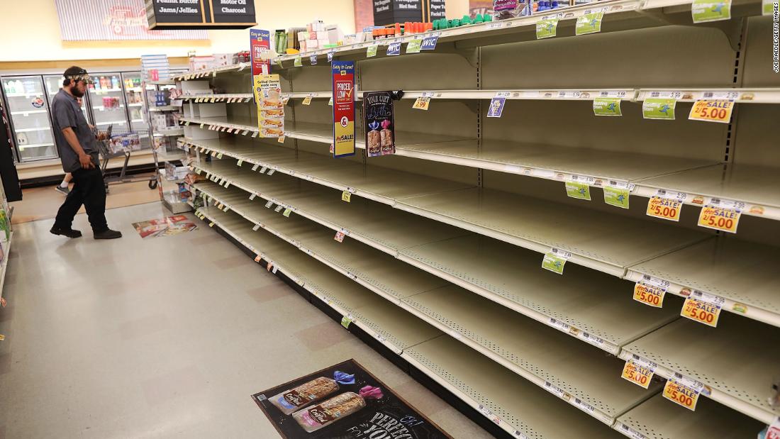 A man eyes a store&#39;s bare bread shelves as people stock up on food in Myrtle Beach on September 11.