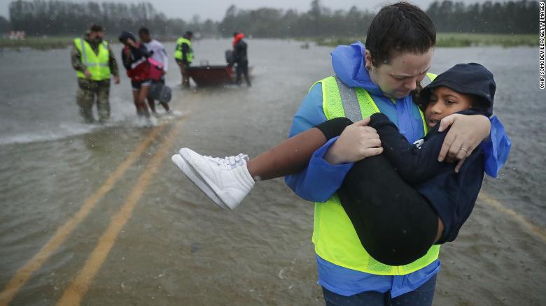 Volunteers help rescue three children from a flooded home Friday, September 14, in James City, North Carolina. 