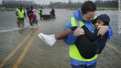 Volunteers from the Civilian Crisis Response Team help rescue three children from their flooded home Friday, September 14, 2018 in James City, North Carolina. 