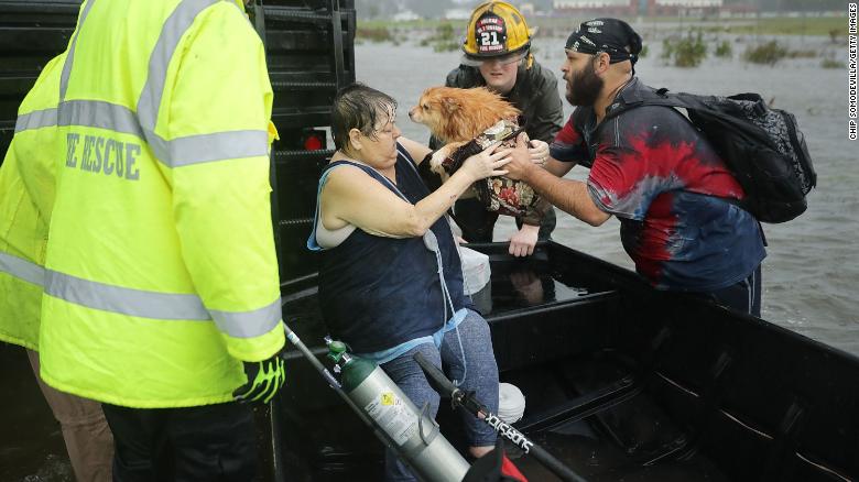 In James City, North Carolina, rescuers help a woman and her dog Friday from their flooded home.