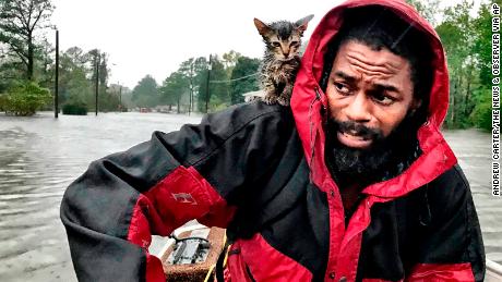 Robert Simmons Jr. and his kitten Survivor are rescued from floodwaters after Hurricane Florence dumped several inches of rain in the area overnight, Friday, September 14 in New Bern.