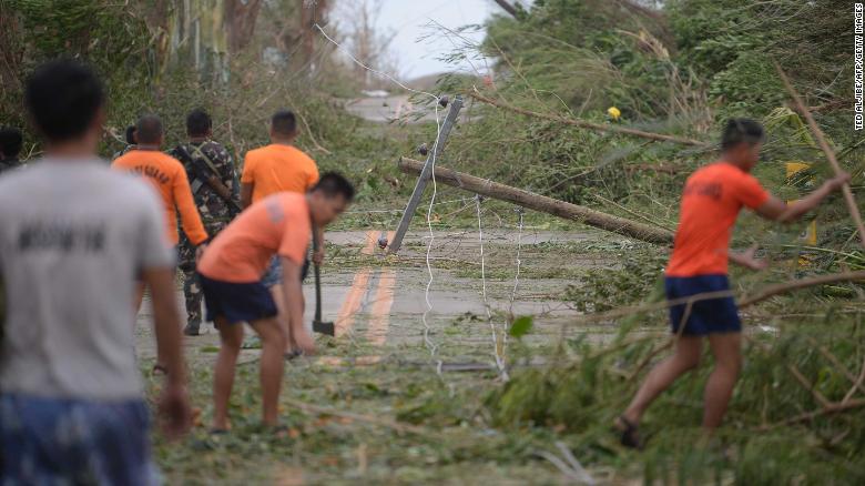 Rescue workers clear a road of debris and toppled electric posts in Cagayan province, north of Manila on Saturday.