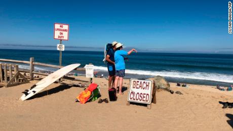 Two people look out at the shore after a reported shark attack at Newcomb Hollow Beach in Wellfleet, Mass,  on Saturday, Sept. 15, 2018.   A man boogie boarding off the Cape Cod beach was attacked by a shark on Saturday and died later at a hospital, becoming the state&#39;s first shark attack fatality in more than 80 years.  (AP Photo/Susan Haigh)