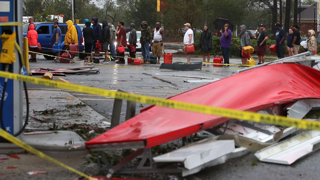 People wait in line to fill gas cans at a gas station that was damaged when Florence hit Wilmington, North Carolina, on Saturday.