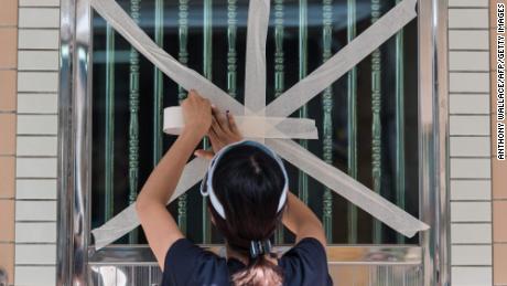 A resident tapes up her front entrance window in the fishing village of Tai O in Hong Kong on September 15, 2018.