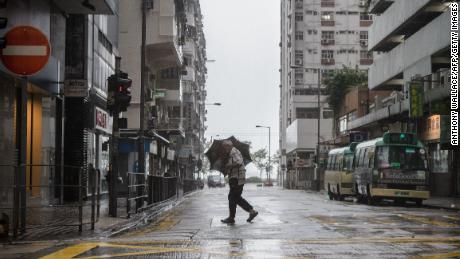 A man uses his umbrella while crossing a road as Mangkhut edges closer to Hong Kong Sunday