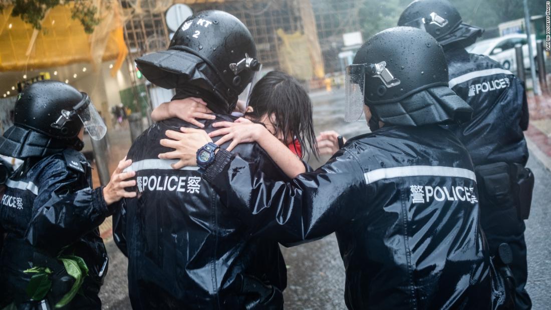 Police officers carry a girl out of a collapsed school in Hong Kong on Sunday.