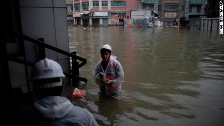 Rescuers evacuate local residents from flooded areas in heavy rains caused by Typhoon Mangkhut in Macau.