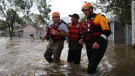 Lumberton Fire and Rescue members help a resident through floodwaters on Monday.