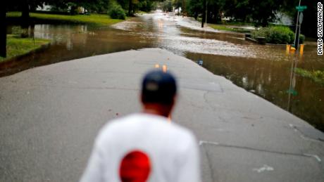 Helen McKoy walks down a flooded street in her neighborhood in Fayetteville on Sunday.