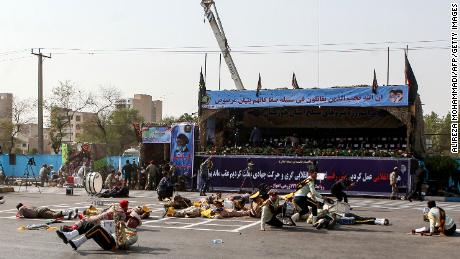 Wounded soldiers lie on the ground after the attack on the military parade.