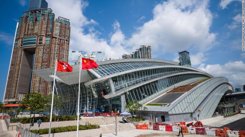 The flags of Hong Kong (L) and China are seen hoisted outside the West Kowloon train station of the High Speed Rail Link to Guangzhou as sales counters were opened to the public for the first time in Hong Kong on September 10, 2018. 