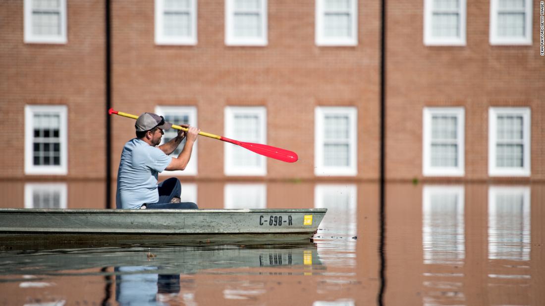 Taylor James navigates floodwaters in a boat in front of Trinity United Methodist Church in Conway, South Carolina on Wednesday, September 26.