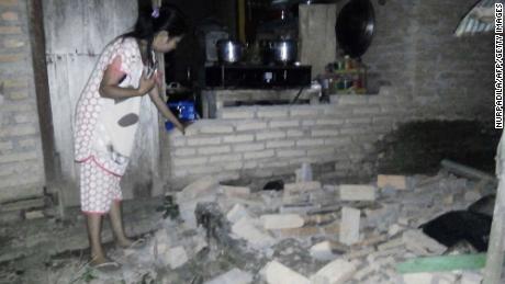強い地震が地域を襲った後、西スラウェシ州中央マムジュのTobadak村で彼女の家の崩壊したレンガの壁の横に居住者が28日に見られます。