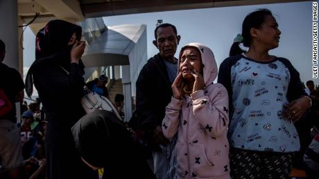 o tânără plânge în afara aeroportului Palu după redeschiderea acestuia pe 1 octombrie. Sute de persoane s-au repezit la aeroport în speranța de a prinde unul dintre puținele zboruri din zonă.