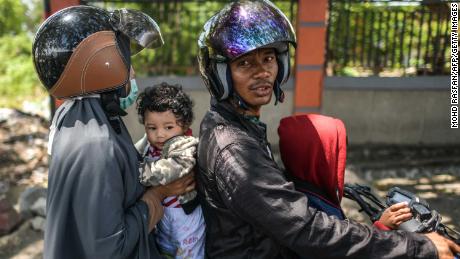 Una famiglia su una moto attende di conoscere lo stato dei parenti il 2 ottobre.