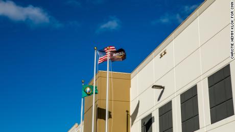 Flags for the United States, Washington state and Amazon wave in the wind outside the fulfillment center in Kent, Washington.