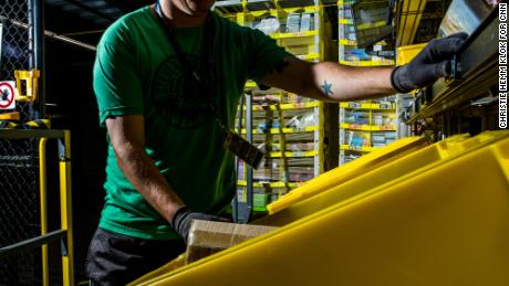 An employee goes through a bin at the fulfillment center.