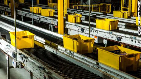 Crates zip through the fulfillment center on a conveyor belt.