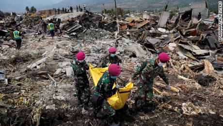 Soldater bærer en død kropp fra ruinene av hus i Palu, Indonesia, torsdag 4.oktober.