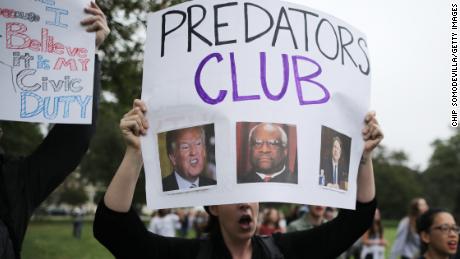 A protester holds up a "Predators Club" sign Saturday on the Capitol's East Lawn.