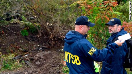 Members of the National Transportation Safety Board work at the scene of Saturday's fatal crash. 