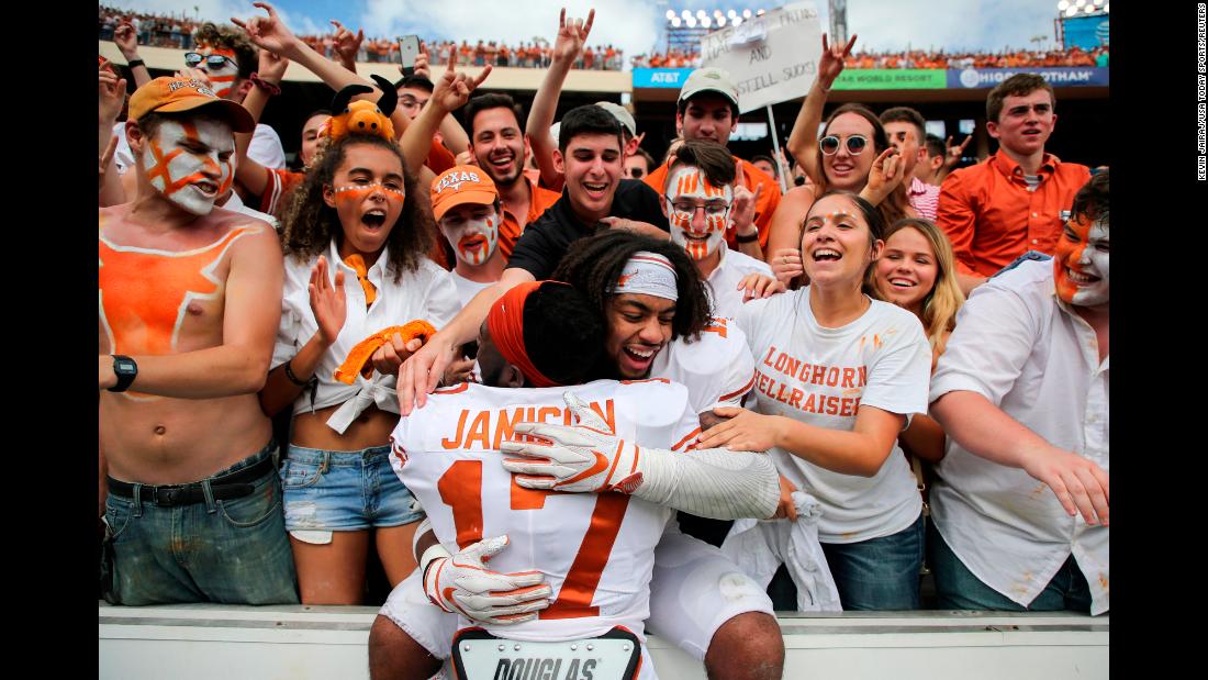 Texas Longhorns defensive back D&#39;Shawn Jamison and defensive back P.J. Locke III celebrate with fans after their game against the Oklahoma Sooners at the Cotton Bowl on October 6, 2018. The Lornghorns won the Red River Showdown by a score of 48-45.
