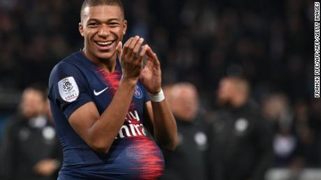 Mbappe hides the match's ball under his jersey after scoring four goals against Lyon.