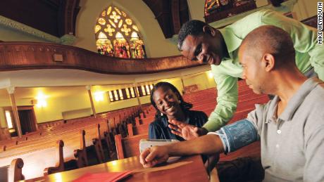 Dr. Olugbenga Ogedegbe, second from right, demonstrates the proper technique for taking blood pressure readings at a church in New York.