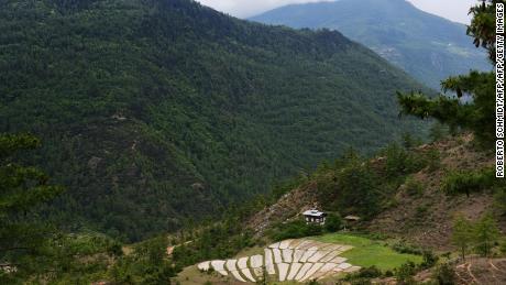 The house of a working farm sits in a valley nestled in the mountains near the eastern Bhutanese town of Paro. 