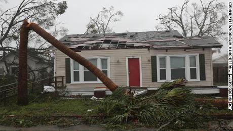 Michael pokes holes in the roof of a Panama City home and snaps a palm tree Wednesday.  