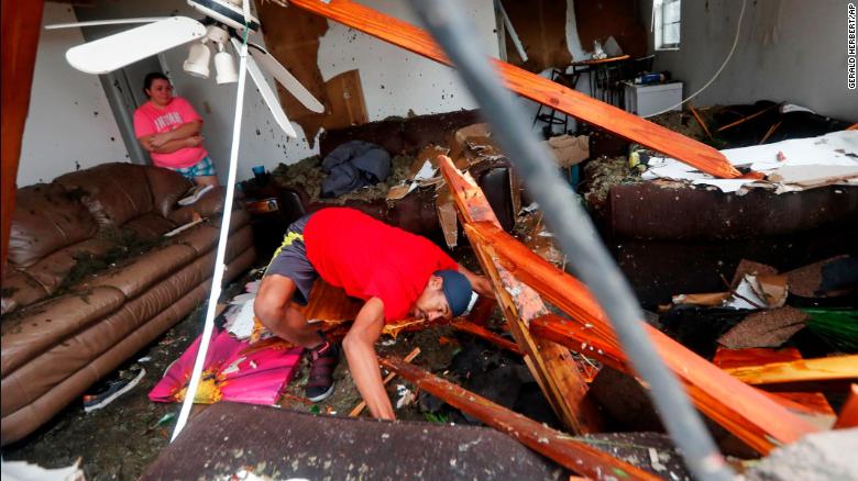 Dorian Carter searches for his missing cat after several trees fell on his Panama City home Wednesday.