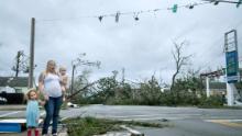 A woman and her children wain near a destroyed gas station after Hurricane Michael in Panama City, Florida on October 10, 2018. - Michael slammed into the Florida coast on October 10 as the most powerful storm to hit the southern US state in more than a century as officials warned it could wreak "unimaginable devastation." Michael made landfall as a Category 4 storm near Mexico Beach, a town about 20 miles (32kms) southeast of Panama City, around 1:00 pm Eastern time (1700 GMT), the National Hurricane Center said. (Photo by Brendan Smialowski / AFP)BRENDAN SMIALOWSKI/AFP/Getty Images