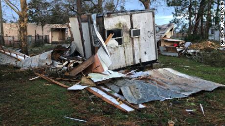 Debris is piled up near a destroyed mobile home. Michael's 150-mph winds damaged many buildings in the area.